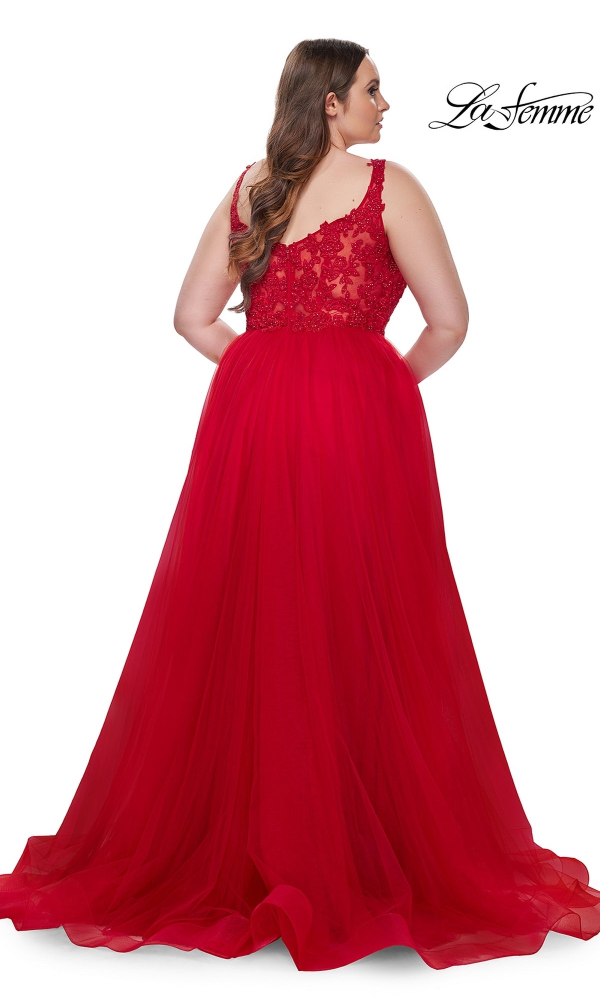 A woman faces away in the La Femme Long Prom Dress 31394—a sleeveless, floor-length red gown with an embroidered lace bodice, sheer flowing skirt, and intricate details. The La Femme logo is visible in the corner.